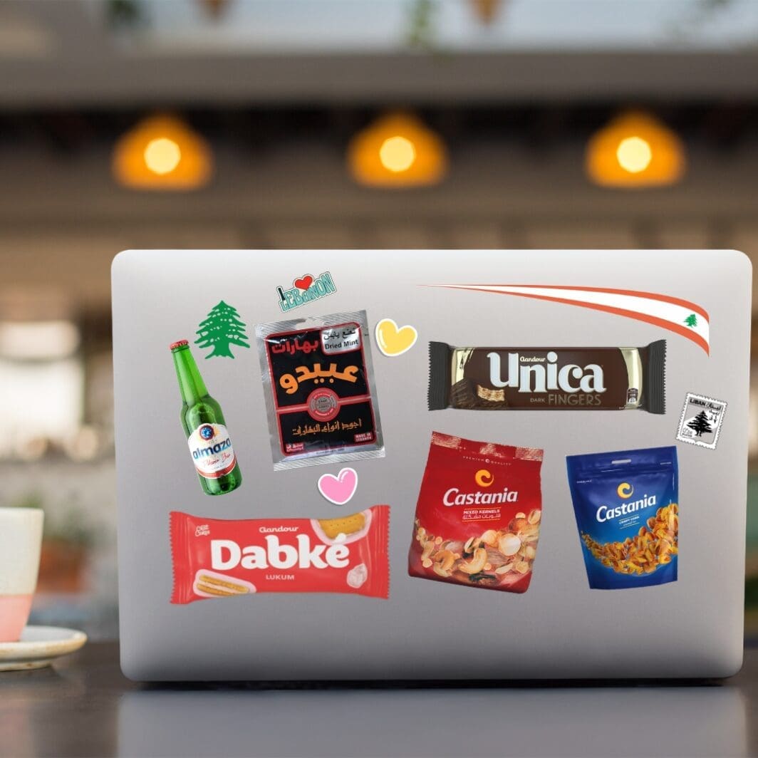 Cover image of the "Lebanon Nostalgia Stickers" digital collection, featuring colorful illustrated icons of nostalgic Lebanese items such as Dabke biscuits, Abido spices, Castania nuts, Unica chocolate, and Ghandour gum, arranged in a playful layout on a light background.